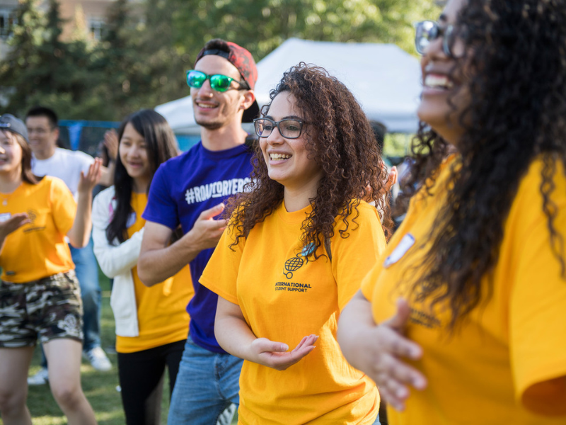Students standing outdoors and smiling at International students event